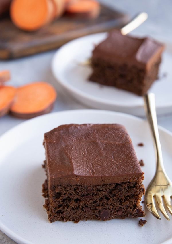 Two slices of chocolate cake on two white plates. Ready to eat.