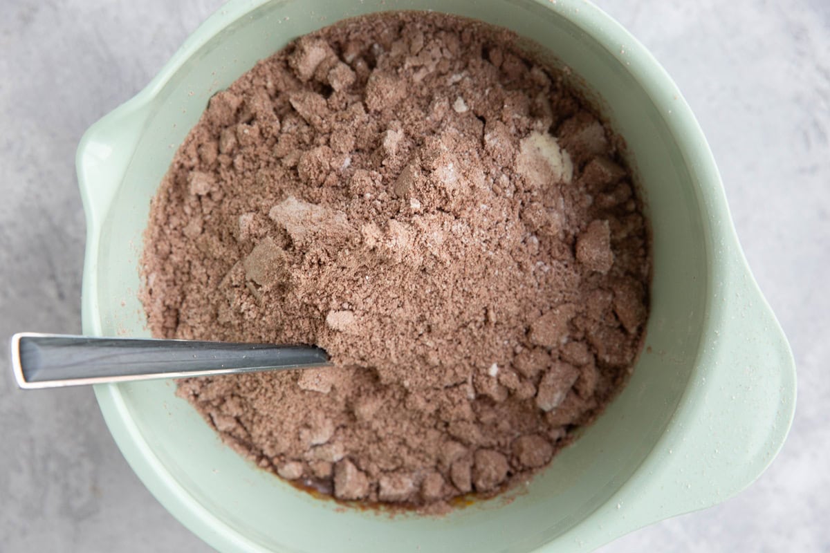 Mixing bowl with wet ingredients on the bottom and dry ingredients poured on top, ready to be mixed in.