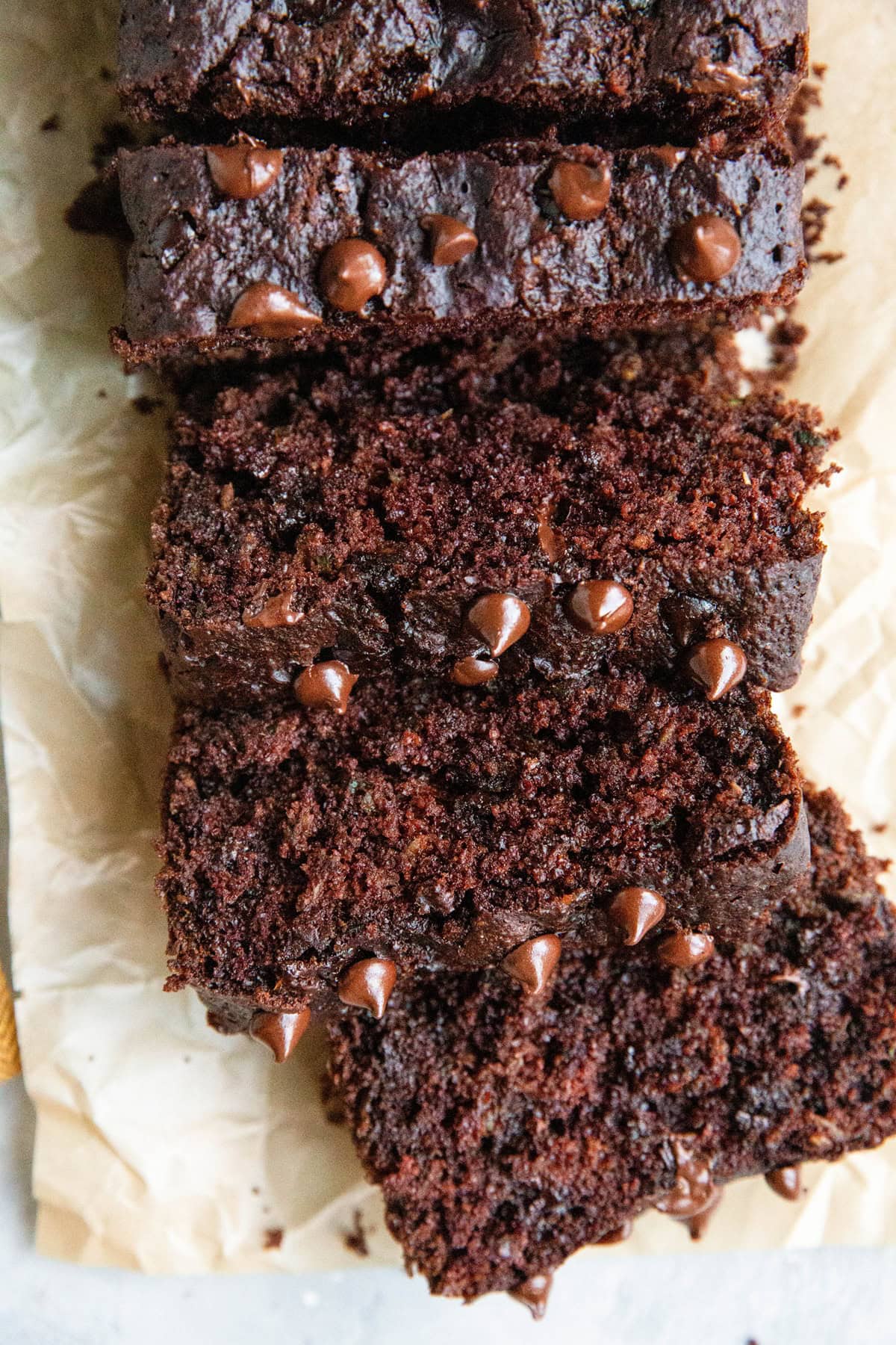 Double chocolate bread on a sheet of parchment paper cut into individual slices.