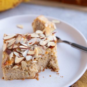 Banana cake with a bite taken out on a plate.