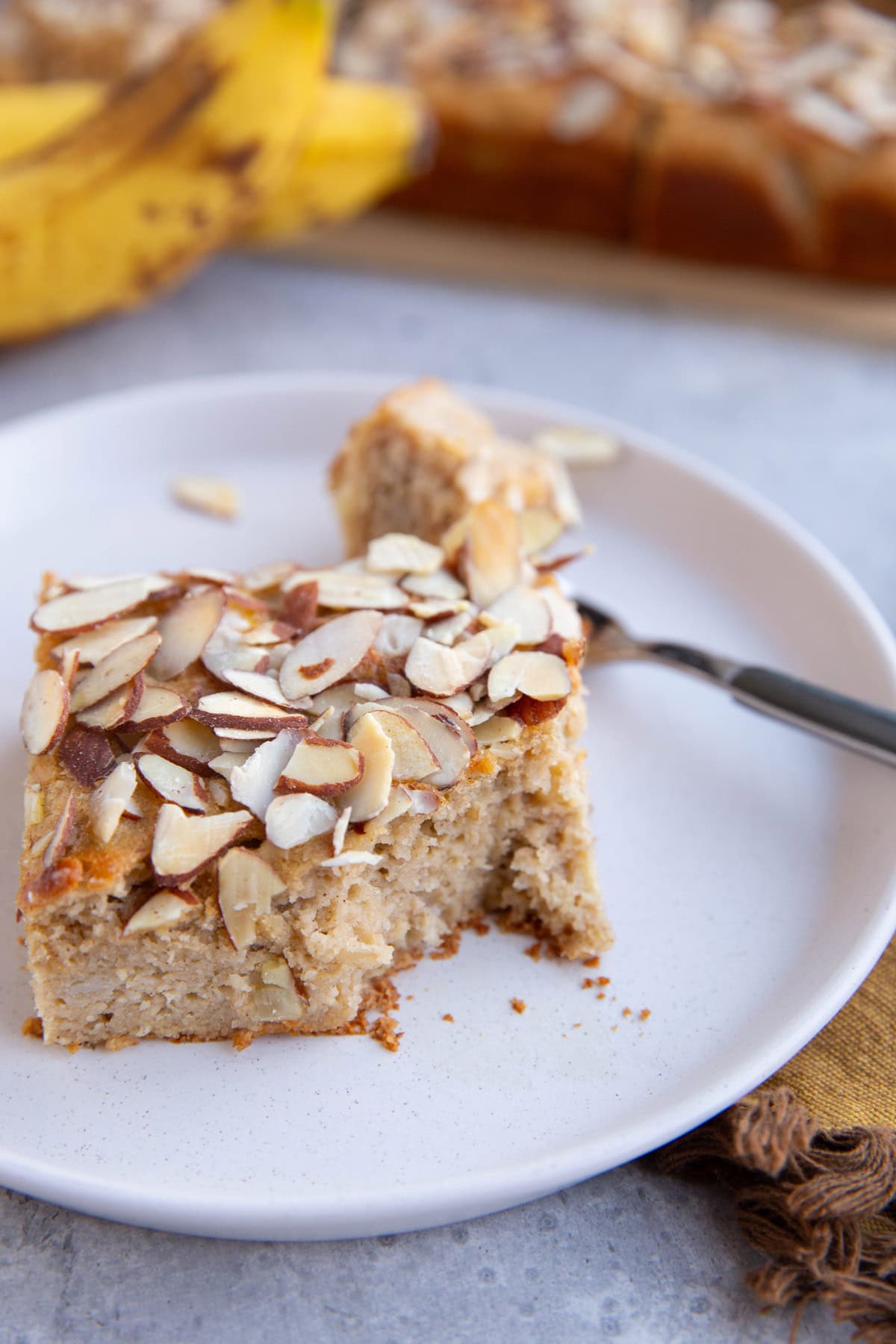 Banana cake with a bite taken out on a plate.