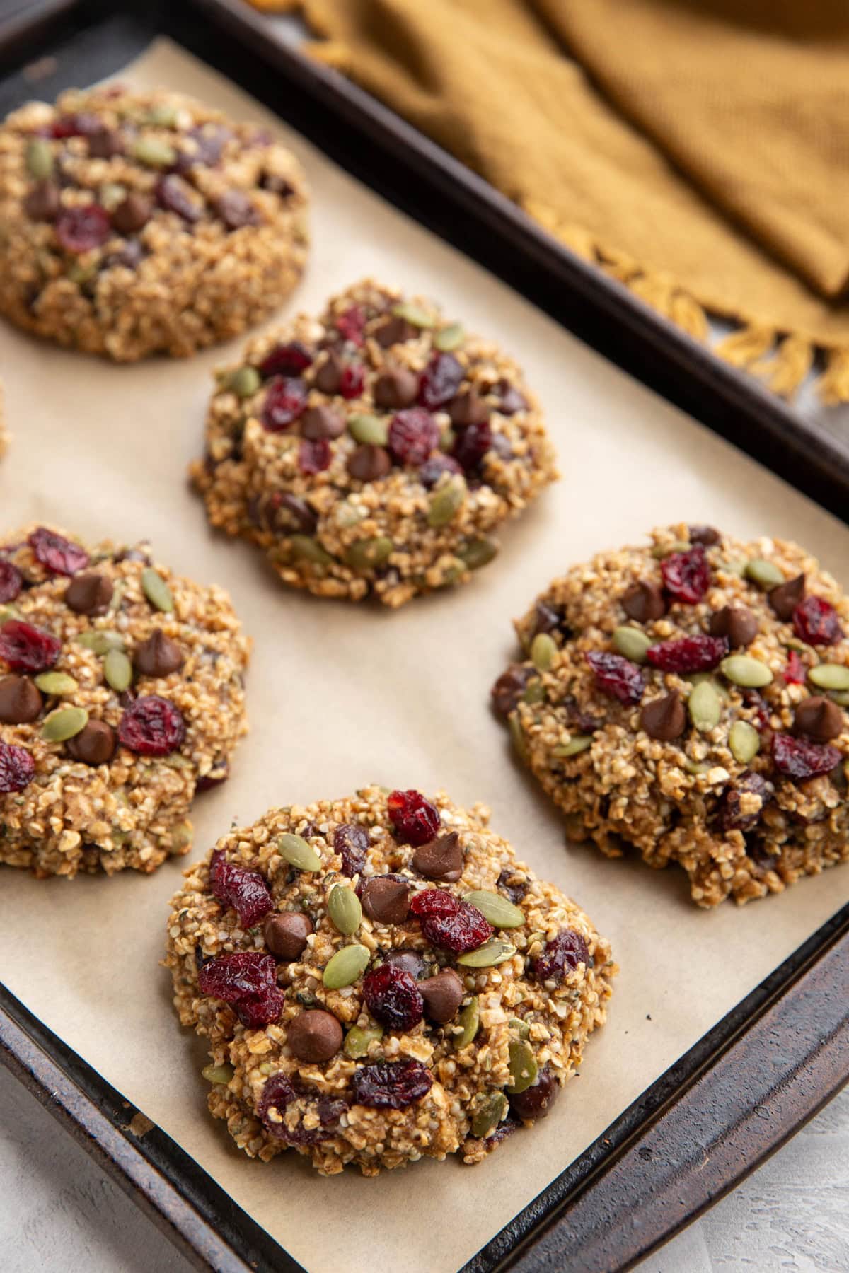 Healthy cookies on a baking sheet with a golden napkin in the background.