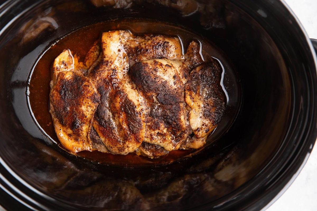 Chicken breasts in a crock pot in spices and juices.