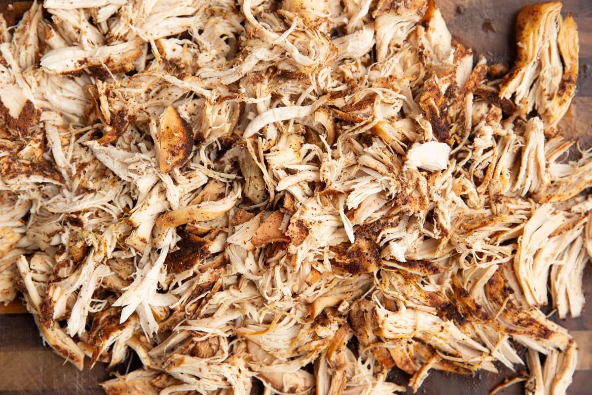 Shredded chicken on a cutting board.