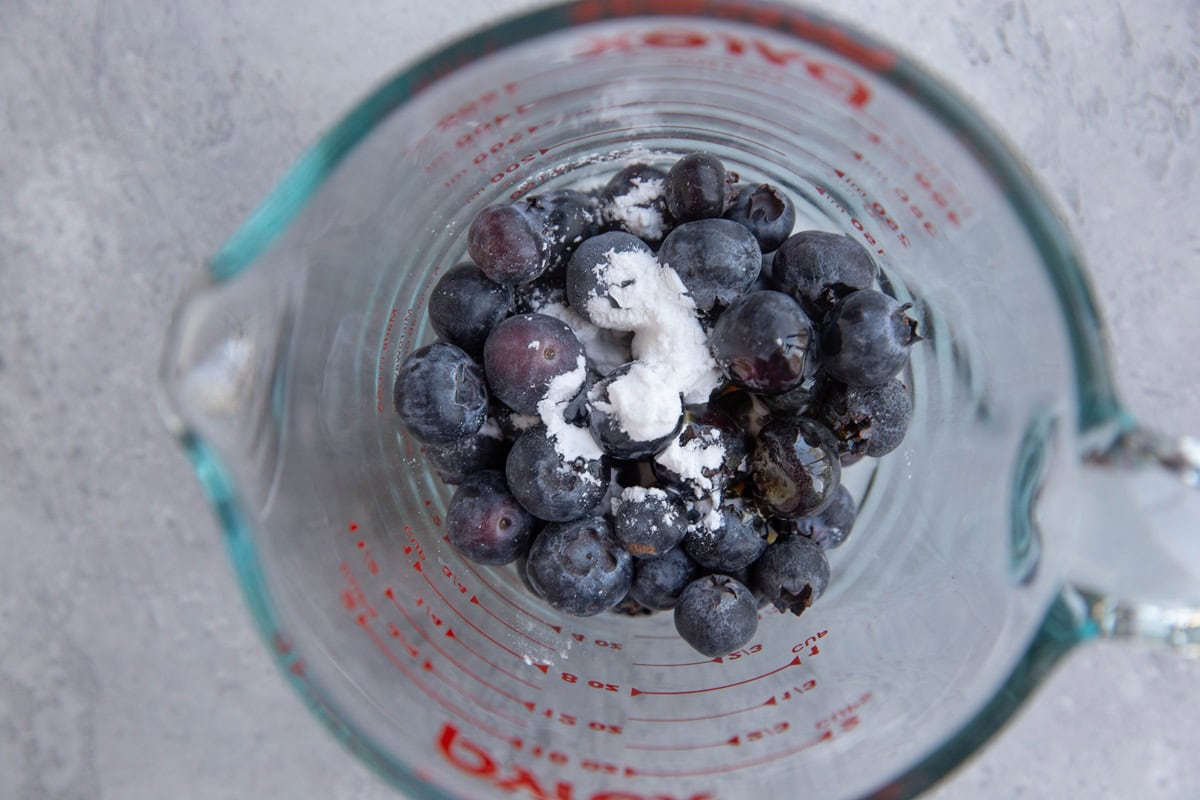 Measuring cup with blueberry filling mixture.